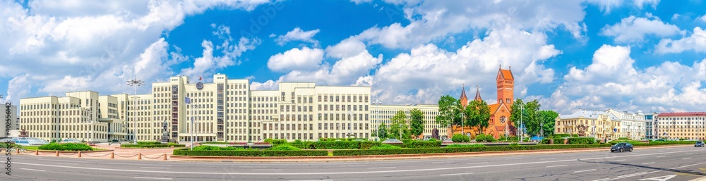 Panorama of Independence Square in Minsk city centre with Government House and Saints Simon and Helena Roman Catholic church or Red Church, blue sky in sunny summer day, Republic of Belarus