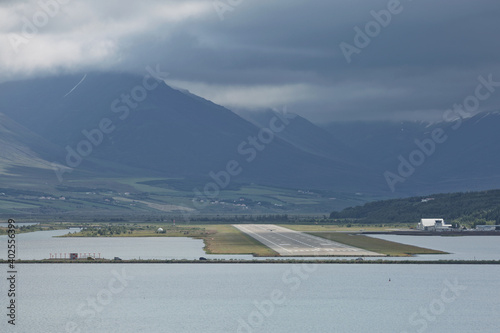 View from the end of runway at Akureyri airport in Iceland. A small plane is taking off