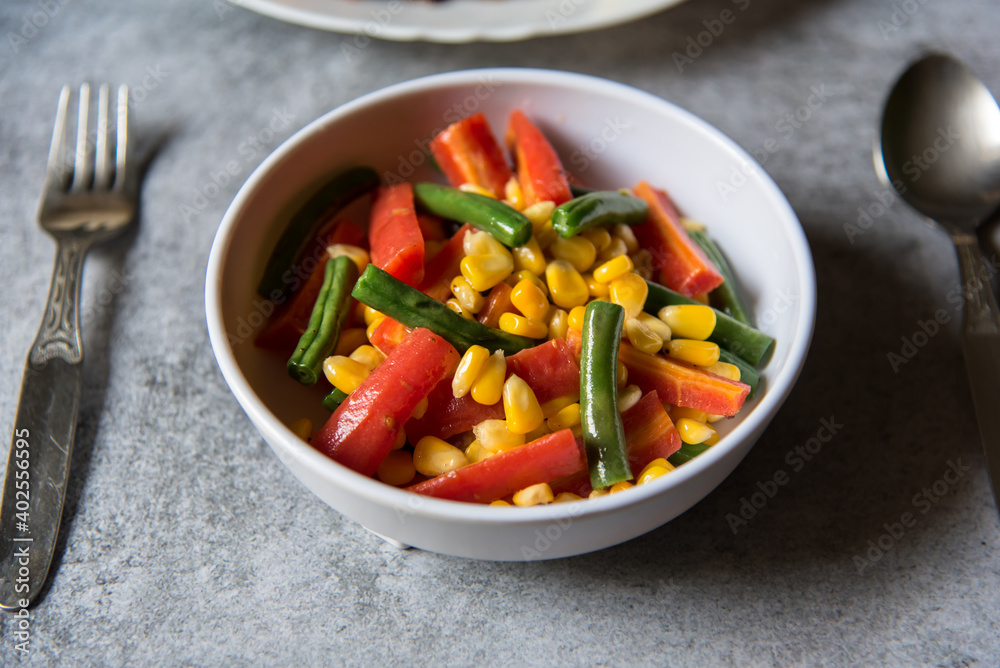 Beans along with boiled vegetables in a bowl with use of selective  focus.