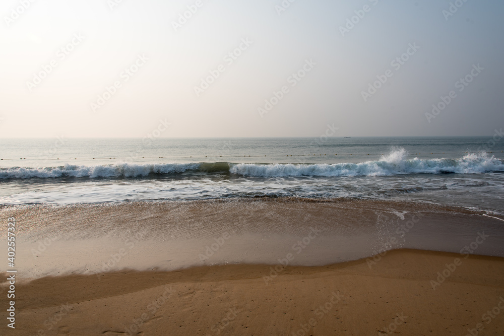 A day at the beach with waves of a calm sea splashing on the shore. A day at the beach with waves of a calm sea splashing on the shore.
