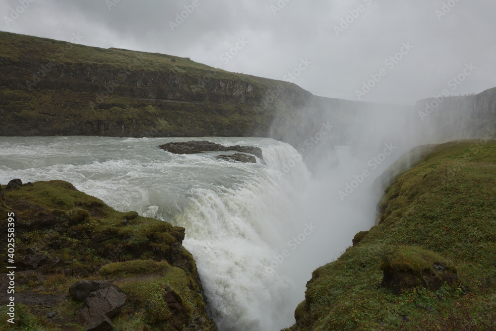People visiting and experiencing the power of popular tourist destination - Gullfoss waterfall on Hvita river in Iceland People visiting and experiencing the power of popular tourist destination - Gullfoss waterfall on Hvita river in Iceland