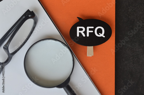 Top view of eyeglasses, magnifying glass, notebooks and wooden tag written with text RFQ stand for REQUEST FOR QUOTATION. Business concept. photo