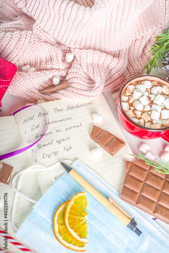 2021 Pandemic Year New Year Resolution Concept. New Year Goals and Resolution background: notepad with new normal covid life goals, christmas decor, hot chocolate, white background flatly top view 2021 Pandemic Year New Year Resolution Concept. New Year Goals and Resolution background: notepad with new normal covid life goals, christmas decor, hot chocolate, white background flatly top view