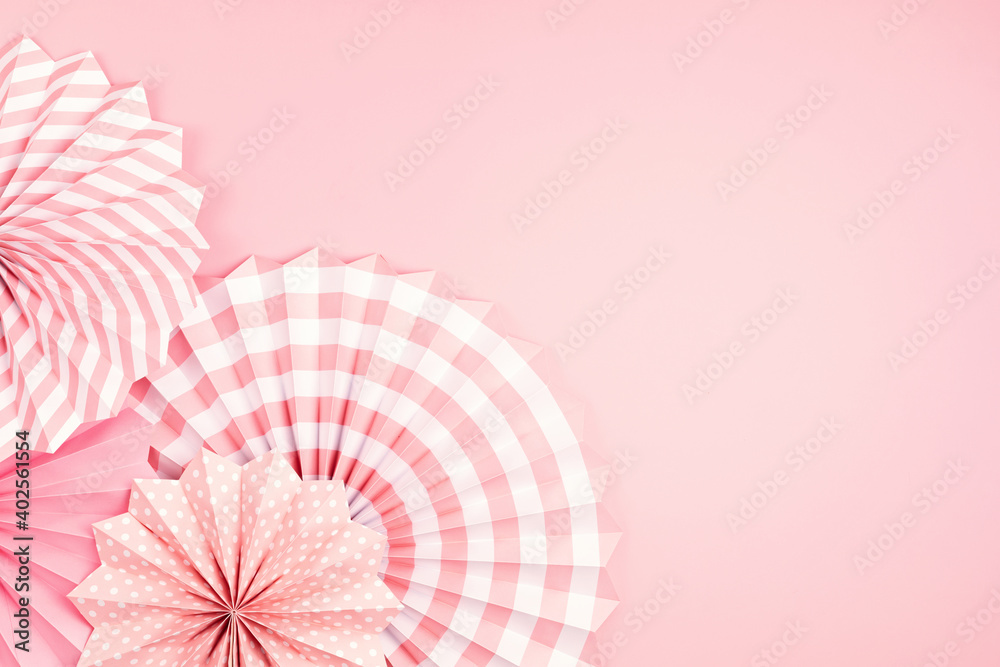 Festive party background with pink paper circle fans over pastel background. Festival, birthday, baby shower decoration