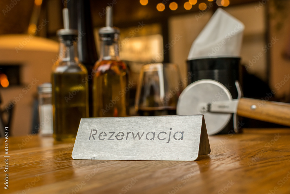 wine bottle and glasses on a table and a reservation sign