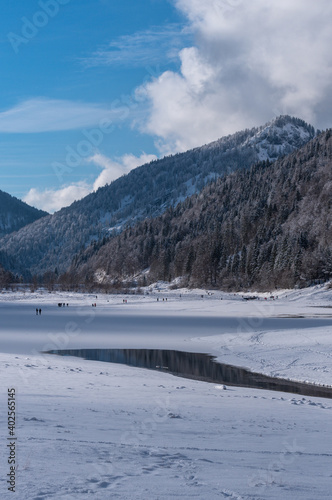 Verschneite Berge  am gefrorenen See im Chiemgau bei blauen Himmel mit Wolken © H. Rambold