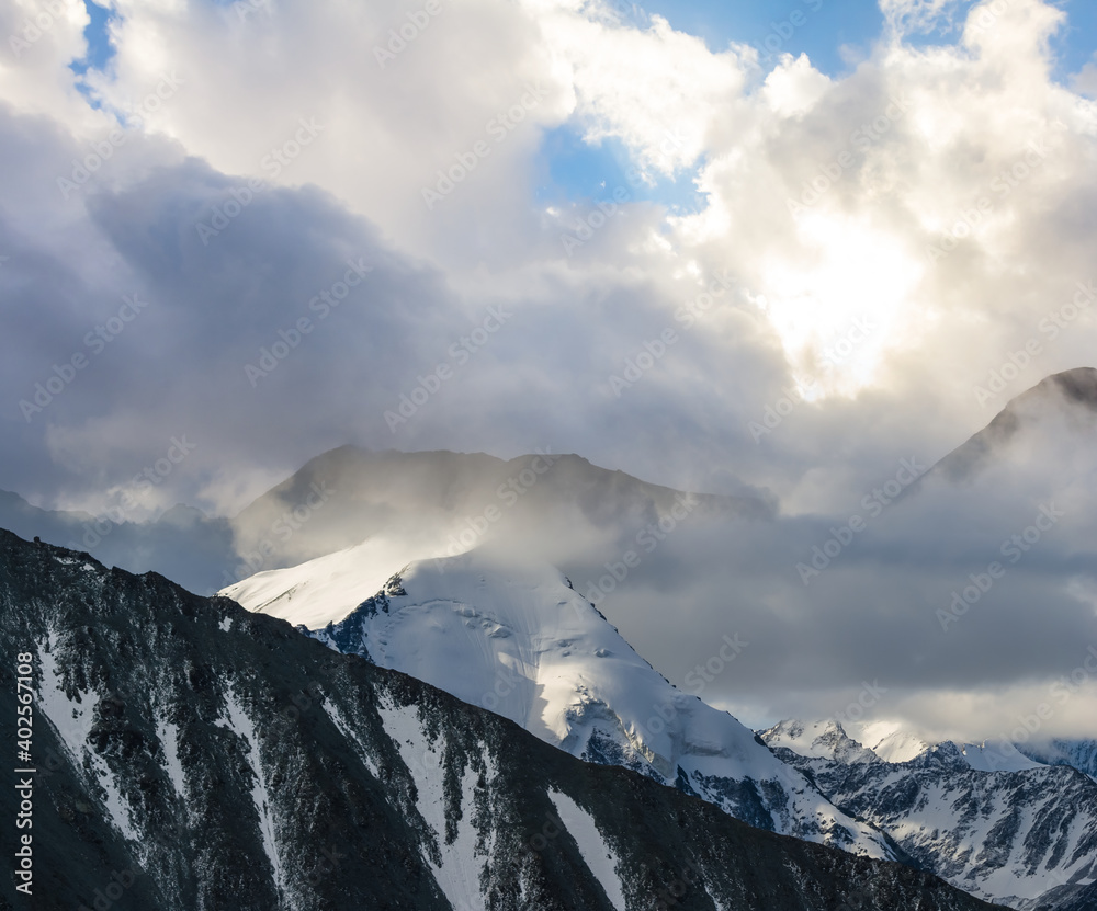 snowbound mountain chain in the dense clouds, natural travel background