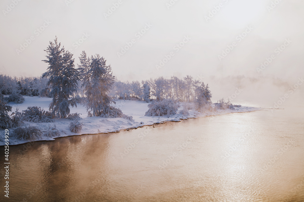 Frosty morning, fog over the river and the water is golden in the sun.