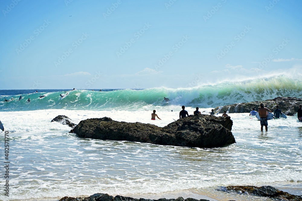 A surfer rides a big uneven wave at Snapper Rocks. The backwash throws ...