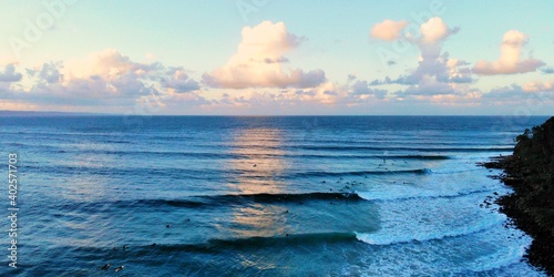 Photos Waves roll in from the horizon as the sunset makes the clouds golden