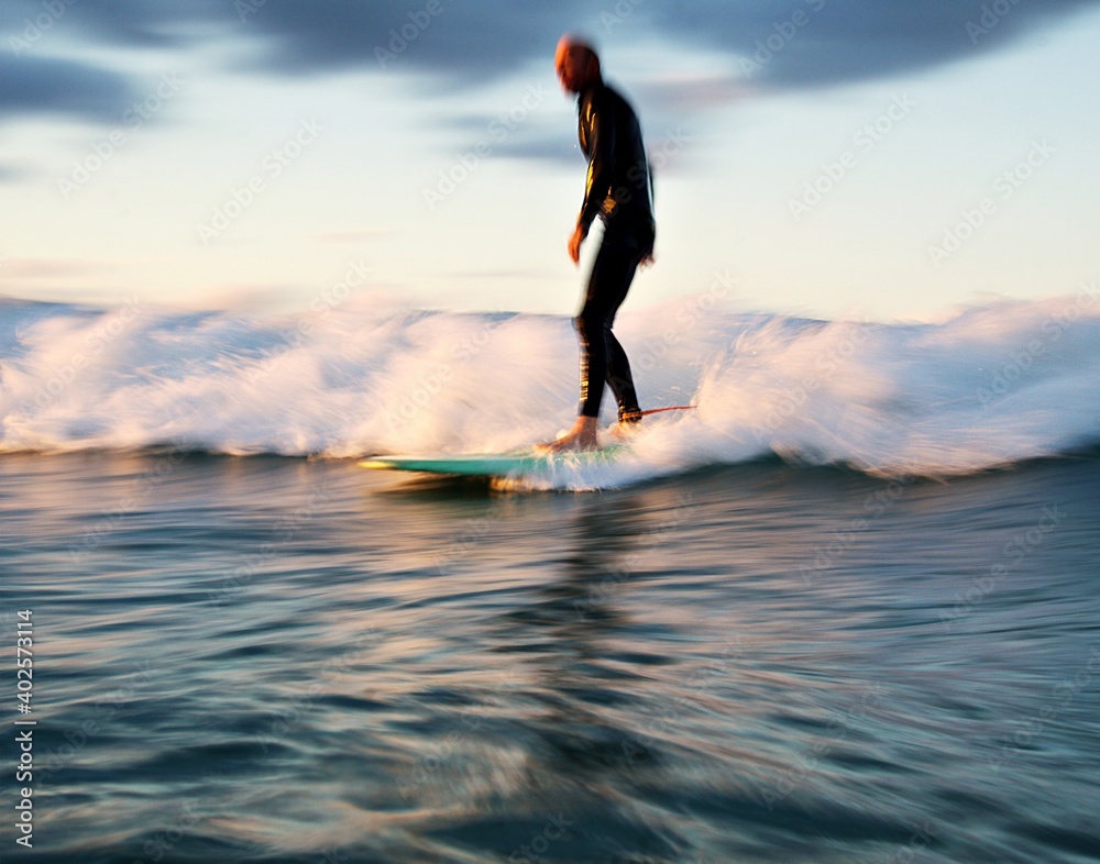 Motion blur - A male surfer rides a foam surfboard in the white water - Gold Coast
