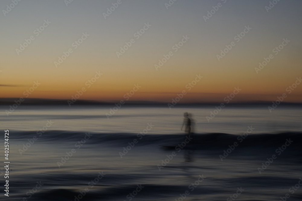 Speed Blur - long exposure of a surfer riding a board along the surface of a colourful wave at sunset - Gold Coast Speed Blur - long exposure of a surfer riding a board along the surface of a colourful wave at sunset - Gold Coast