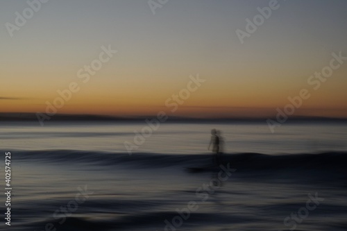 Speed Blur - long exposure of a surfer riding a board along the surface of a colourful wave at sunset - Gold Coast © William