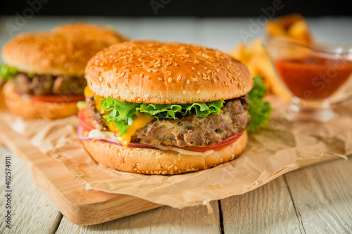 Fresh hamburger with beef and tomato sauce on wooden board