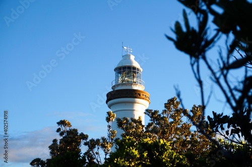 Stampa su tela The Cape Byron lighthouse bathed in golden sunlight as the sun sets - Byron Bay