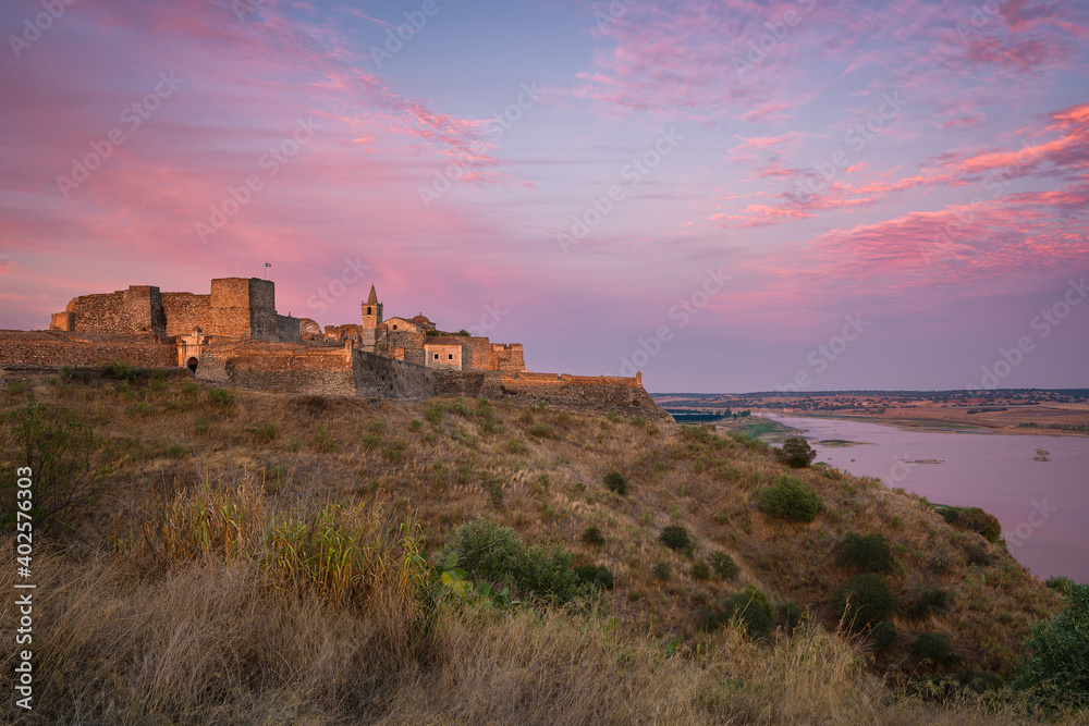 Juromenha castle and Guadiana river and border with Spain on the side of the river at sunset, in Portugal