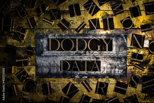 Dodgy Data text surrounded by letters on grunge textured copper and gold background photo