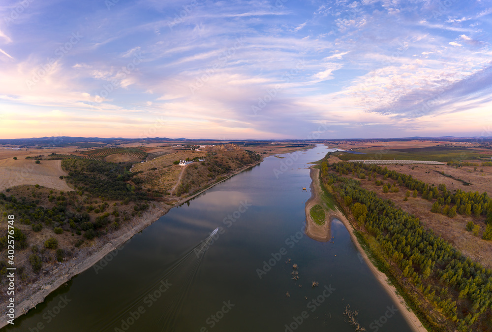 Juromenha castle, village and boat in Guadiana river drone aerial view at sunset in Alentejo, Portugal