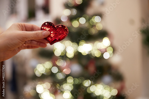 red heart with sequins in hand and bokeh