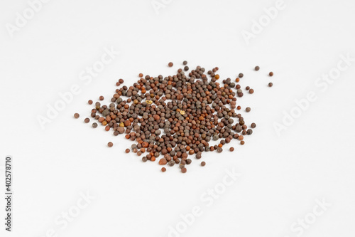 Heap of brown mustard seeds on a neutral background