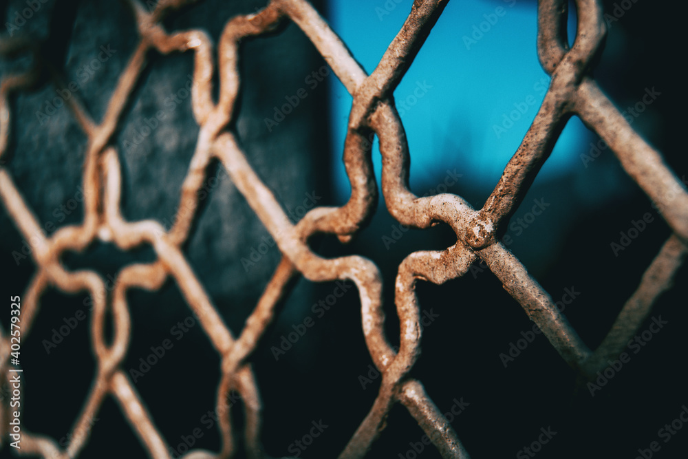 window with a rusty grille with a wrought pattern window with a rusty grille with a wrought pattern