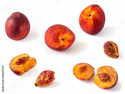 Beautiful, juicy, ripe peaches, broken and whole, as well as their seeds, close-up. Peaches isolated on white.