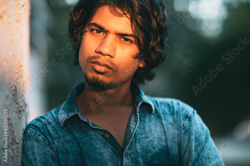 Canvas Print Handsome long hair young man portrait at outdoor in evening light