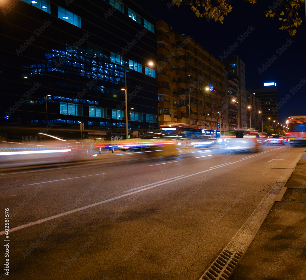 Buses and cars moving at night on the road.