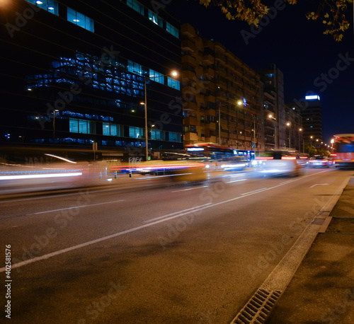 Buses and cars moving at night on the road. © Andrea