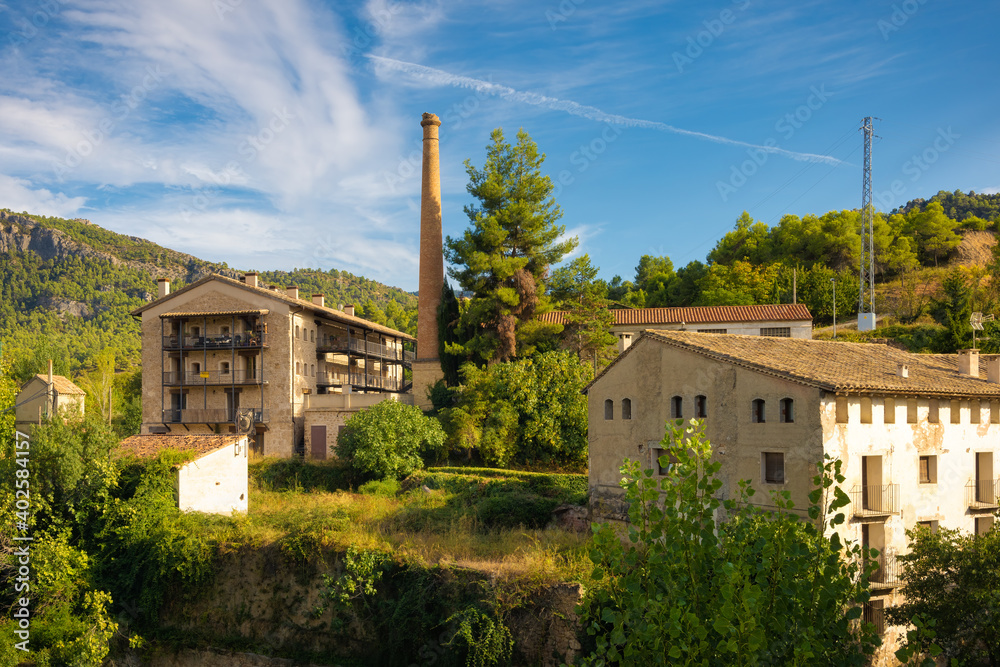 View from the Matarranya river of the reconstructed chimney of an old factory in Beceite, Aragon Spain