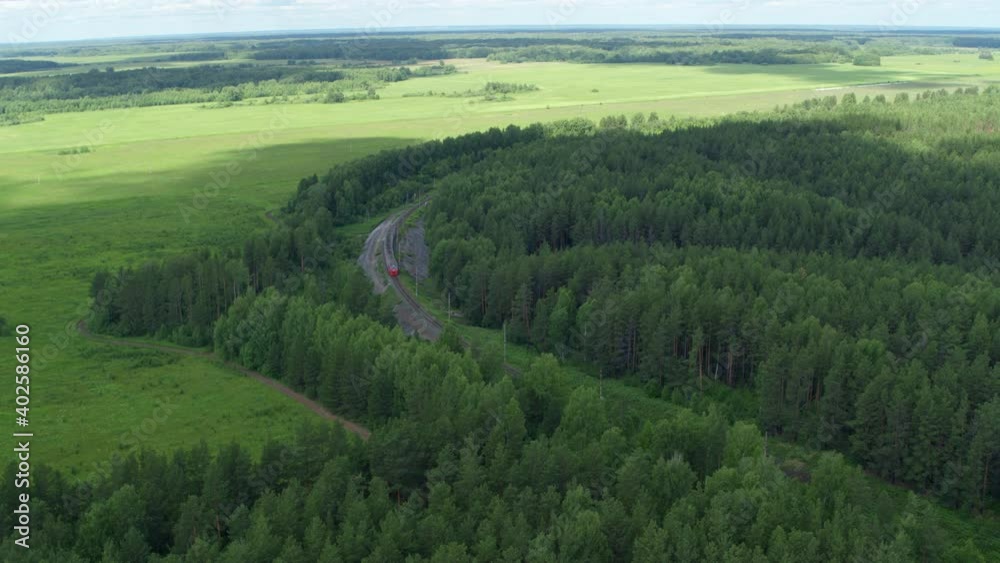 Aerial view of the train that goes through the forest and fields Aerial view of the train that goes through the forest and fields
