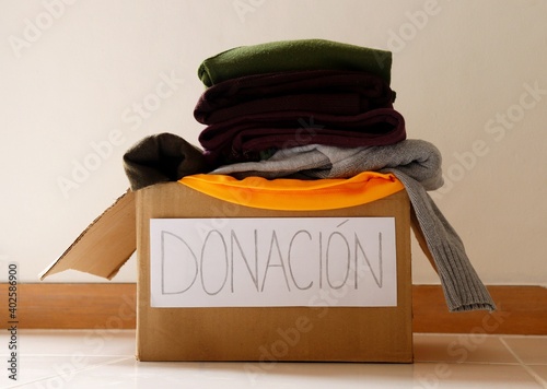 Donation written in Spanish (Donación) on a cardboard box. Clothes donation concept. photo