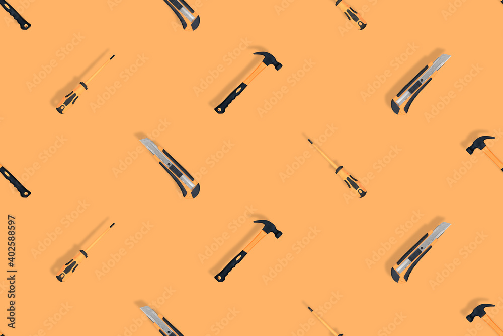 Tools seamless pattern. Tools: hammer, screwdriver and knife on an orange background. Tools seamless pattern. Tools: hammer, screwdriver and knife on an orange background.