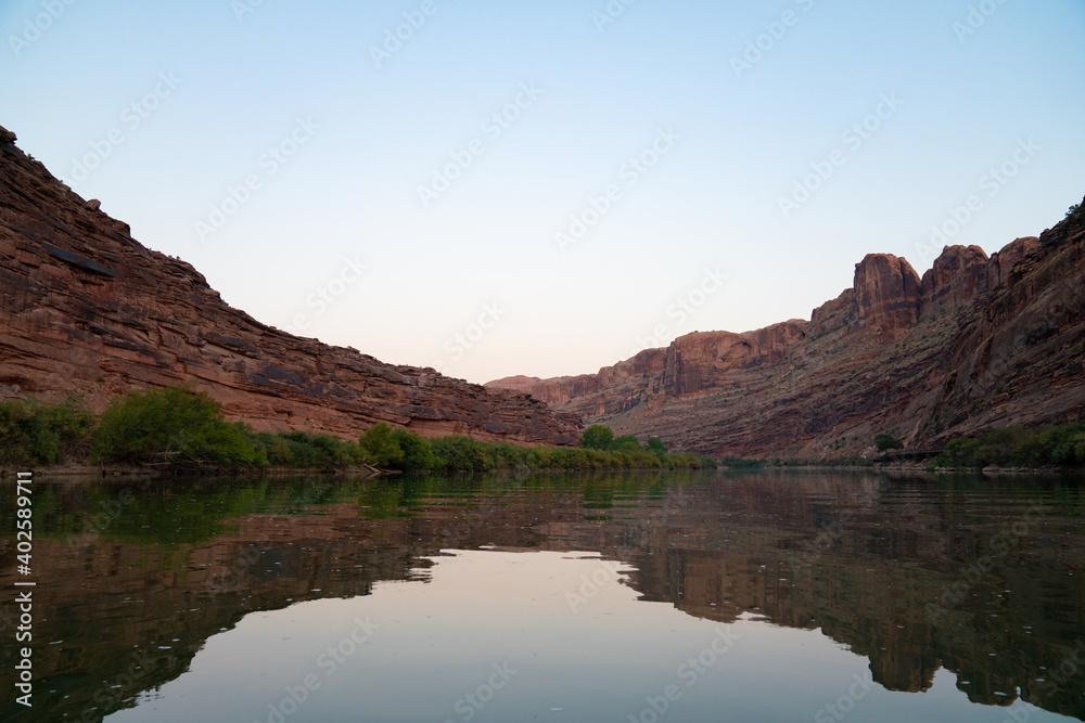 calm river surrounded by red mountain formations