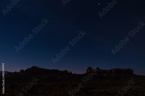 desert mountain landscape with many stars in the background at night