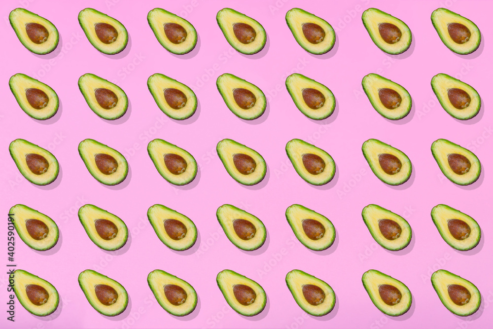 Avocado fruit cut in two halves on pink background. Avocado fruit cut in two halves on pink background.
