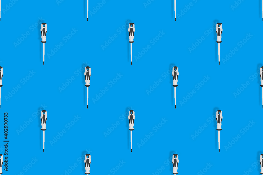 Screwdrivers seamless pattern. Metal screwdrivers with a rubberized handle on a blue background. Screwdrivers seamless pattern. Metal screwdrivers with a rubberized handle on a blue background.