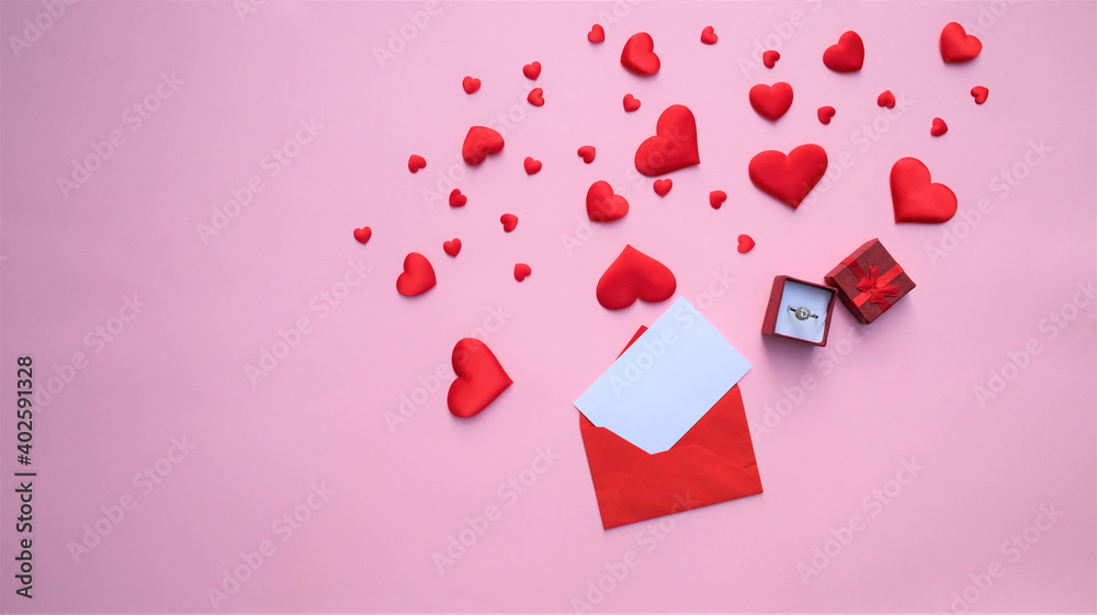 many red hearts, an envelope and a gift on a pink background.