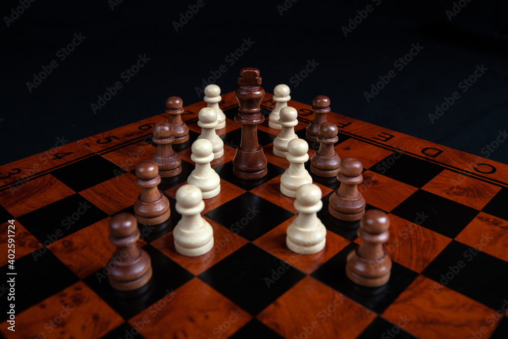 chess pawns and king on a board on a black background chess pawns and king on a board on a black background