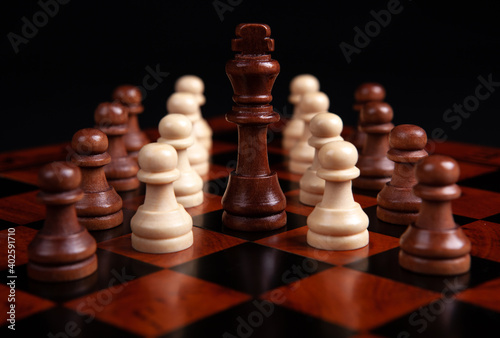 chess pawns and king on a board on a black background