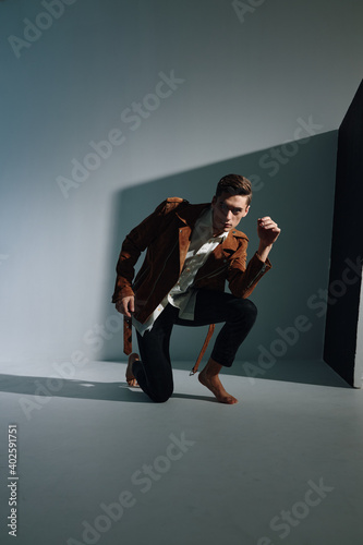 handsome man in brown jacket and trousers in a damp room is kneeling