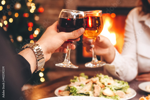 Man and woman drink red and white wine.    lose-up of hands with glasses. They celebrate the new year.