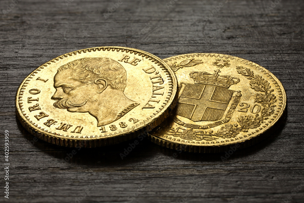 Italian 20 Lira gold coins on rustic wooden background Italian 20 Lira gold coins on rustic wooden background