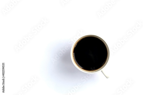 Black coffee in a white cup with shadows isolated on white table.