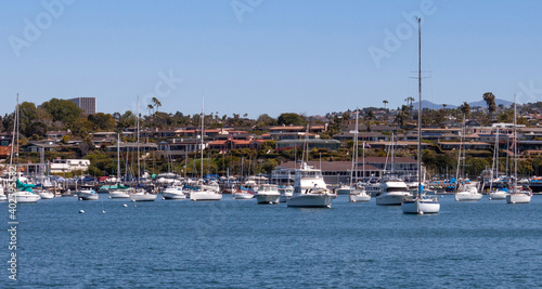 boats moored in Newport Beach harbor in California on a sunny day city skyline in background
