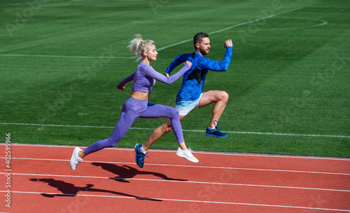 success at any cost. fitness couple training outdoor. runners on running track. challenge and competition. endurance. energy stamina. fit sporty people jumping. man and woman sport trainer run