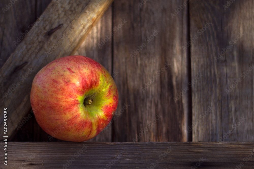 fresh organic apple on the weathered wooden background - close up and still life with fresh crop, healthy food and bio fruit, farming and gardening