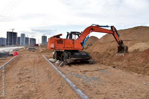 Excavator dig the trenches at a construction site. Trench for laying external sewer pipes. Sewage drainage system for a multi-story building