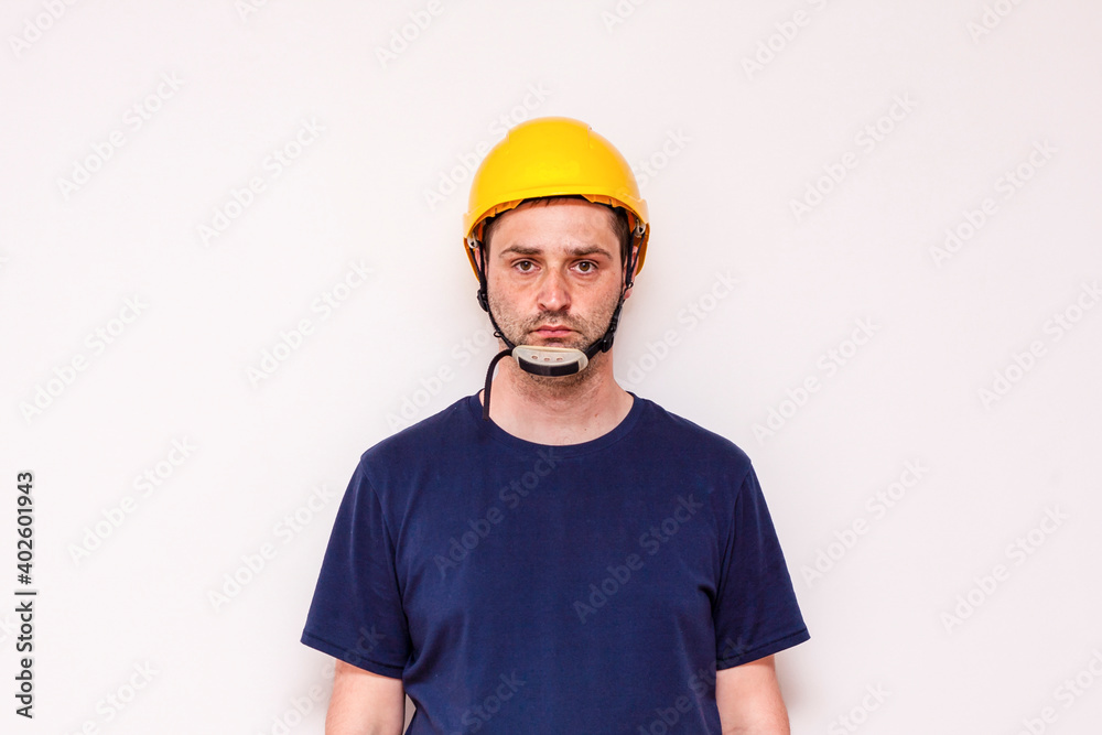 Constraction worker behind white background. Wearing green mask and yellow helmet