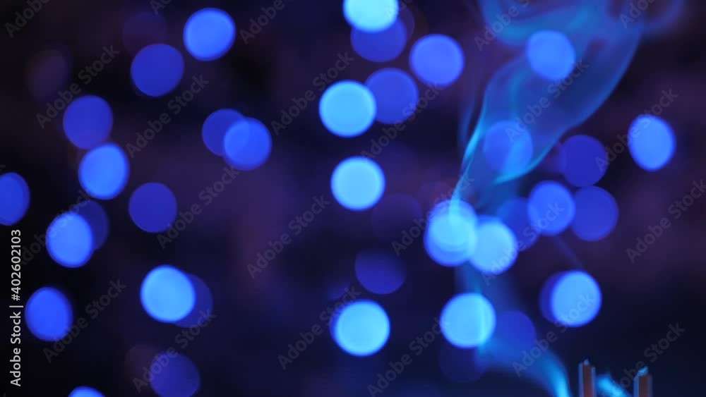Blue smoke moves up slowly, round lights move in the background, smoke and lights are blurred Blue smoke moves up slowly, round lights move in the background, smoke and lights are blurred